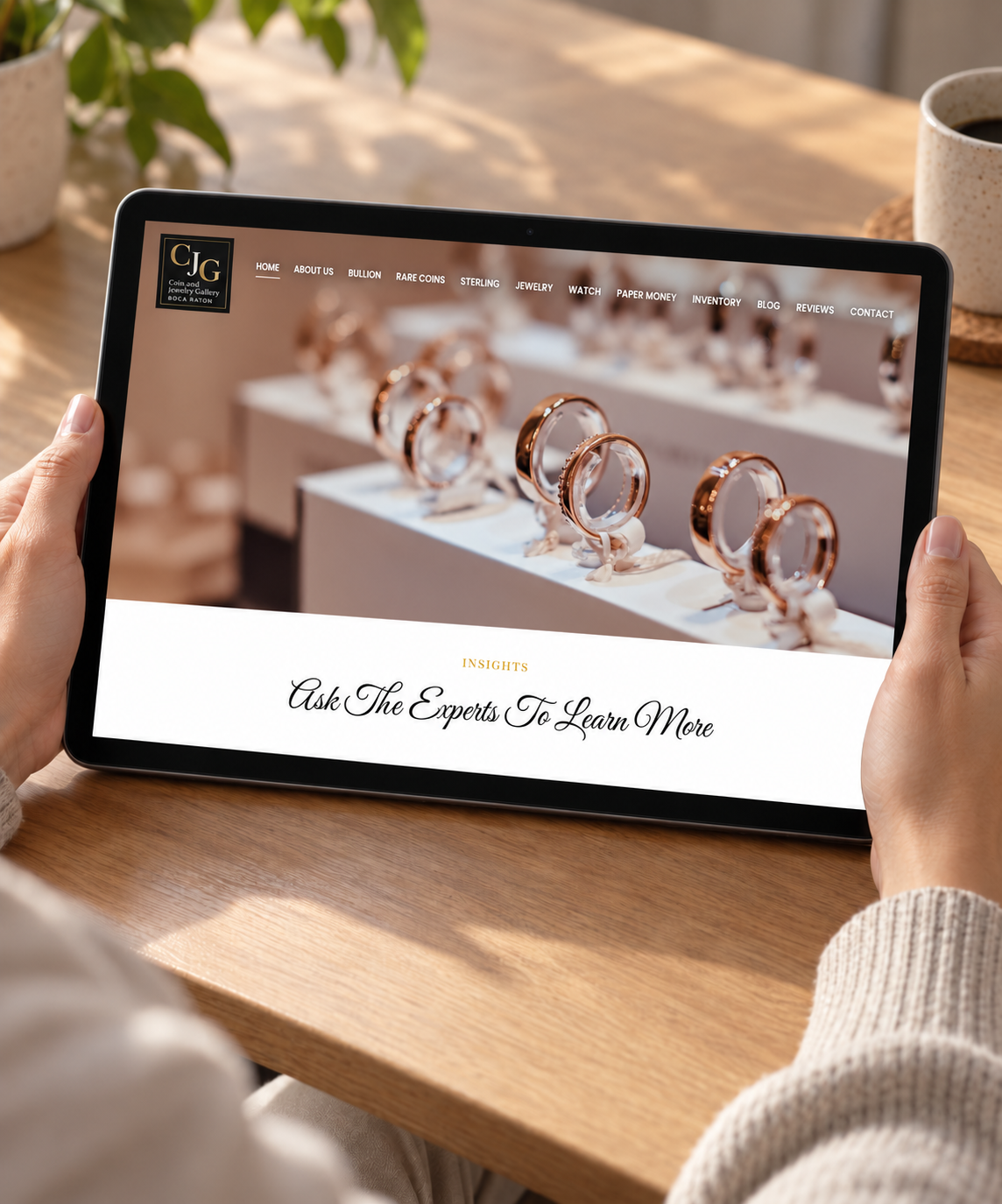 Coin & Jewelry Gallery of Boca Raton website displayed on a handheld tablet