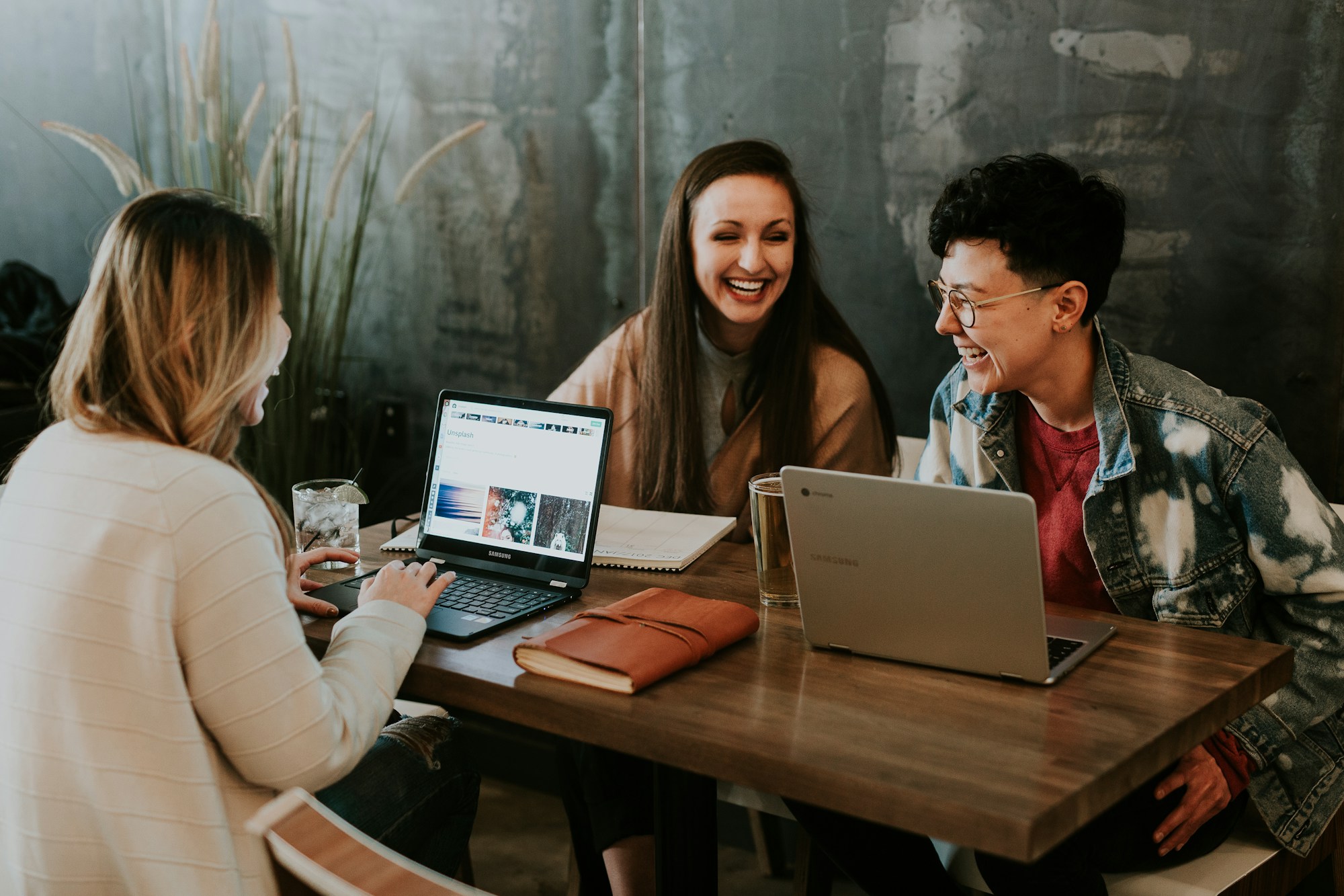 A small team discussing content together around laptops